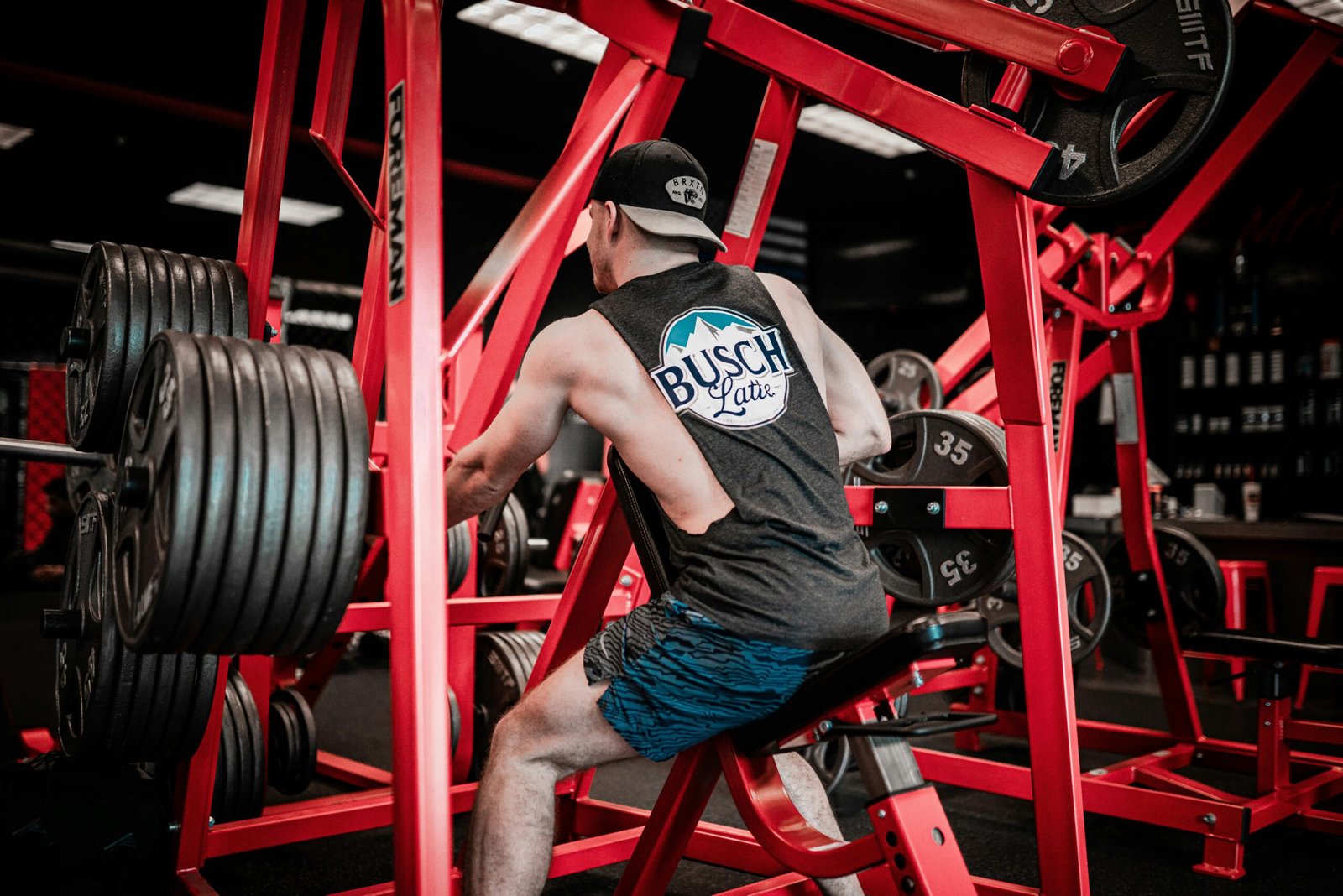 man in gray t-shirt man in gray t-shirt and blue denim jeans sitting on red metal bar
